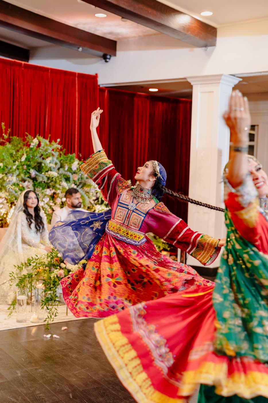 A dancer arching back with the bride and groom behind her