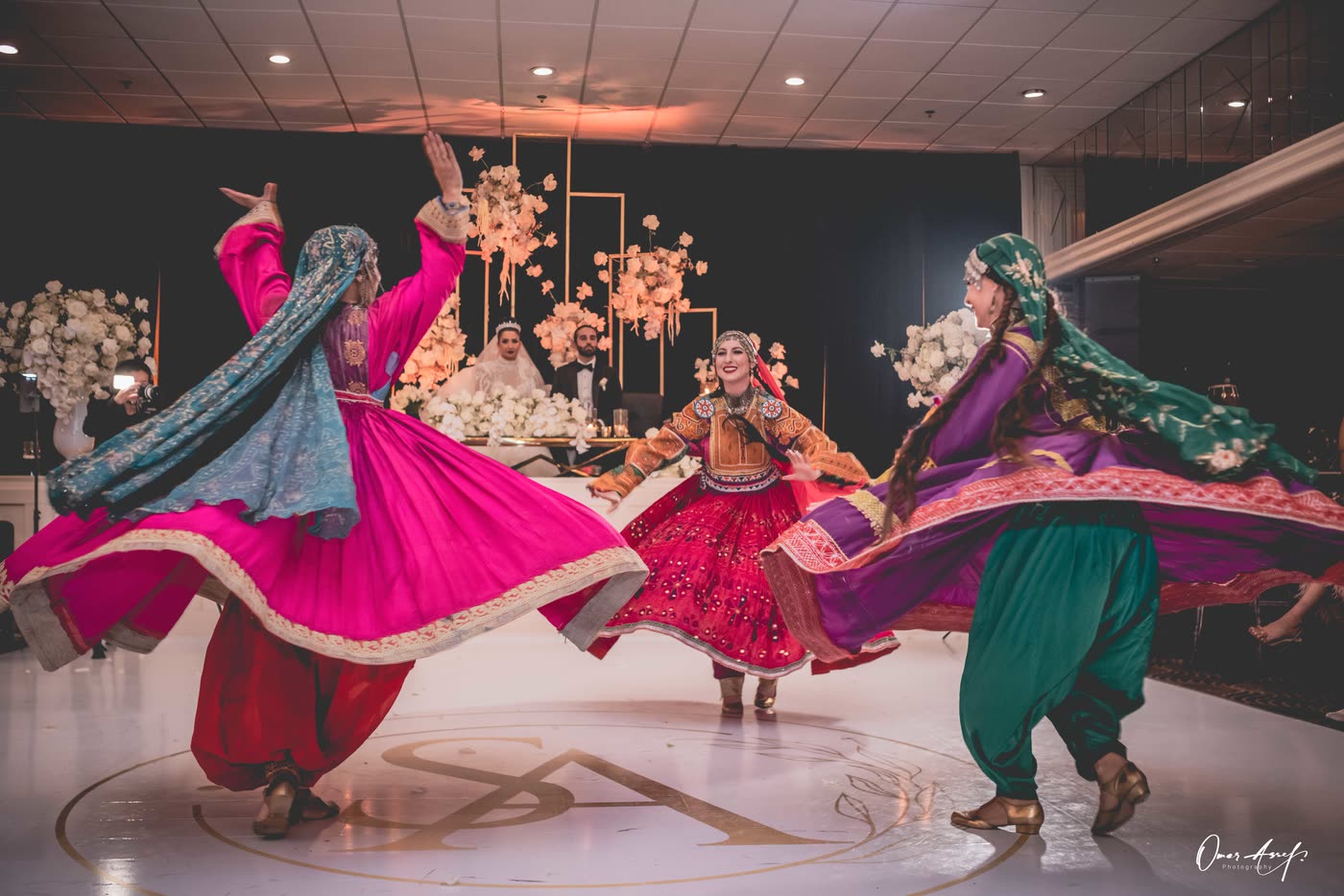 Three dancers whirling in front of the bride and groom